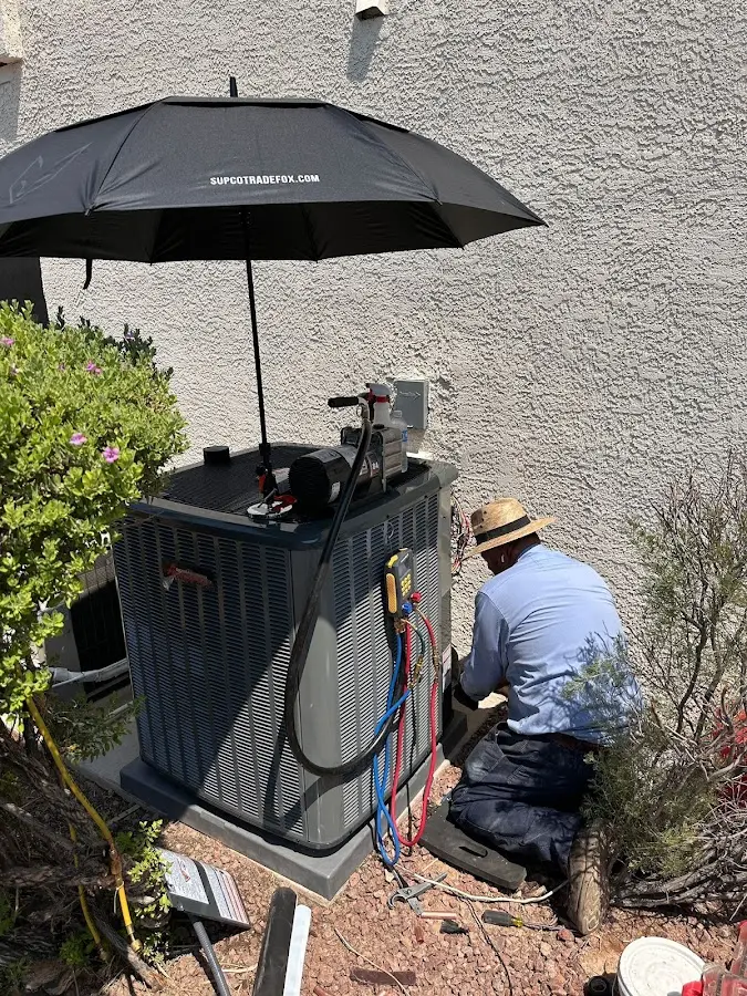 HVAC technician performing outdoor AC maintenance in East Ridge